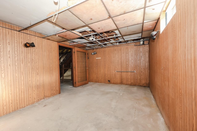 basement featuring wooden walls