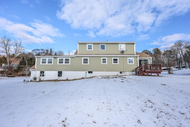 snow covered house featuring a deck and ac unit