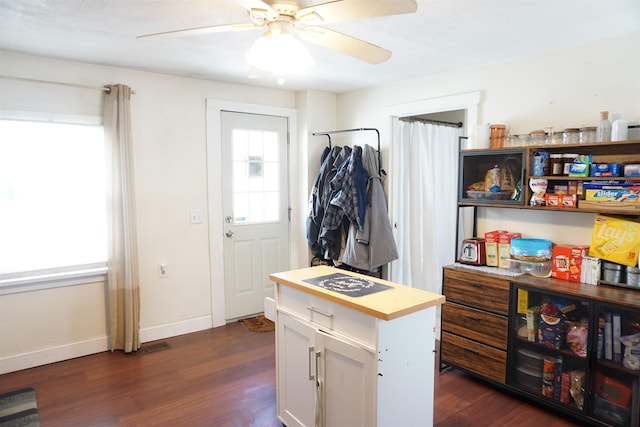 kitchen featuring white cabinetry, a kitchen island, a healthy amount of sunlight, and dark hardwood / wood-style flooring