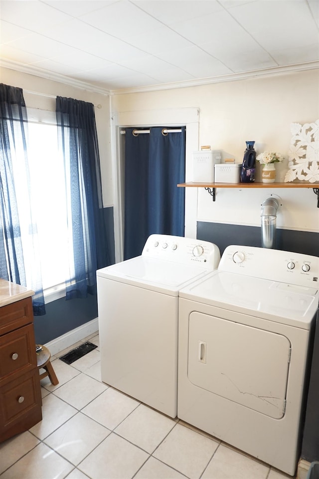 laundry room featuring light tile patterned floors, ornamental molding, and washer and dryer