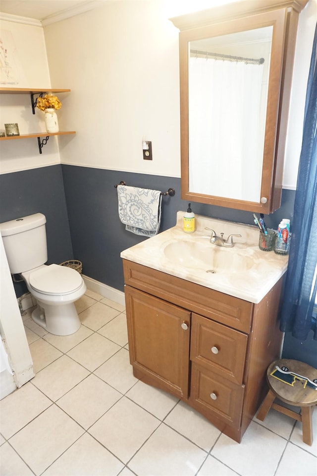 bathroom featuring vanity, tile patterned flooring, crown molding, and toilet