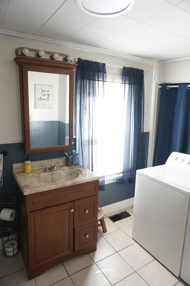 bathroom featuring vanity, tile patterned flooring, washer / dryer, and ornamental molding