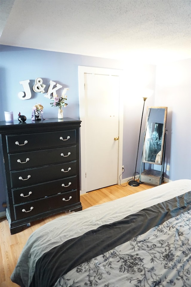 bedroom featuring hardwood / wood-style floors, a closet, and a textured ceiling