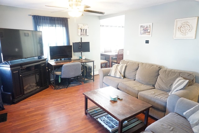 living room featuring wood-type flooring and ceiling fan