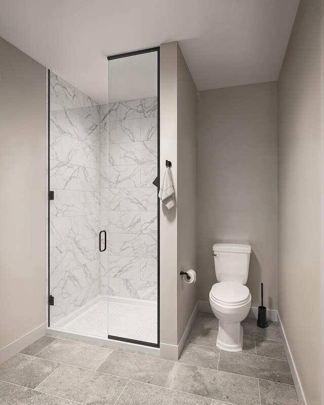 full bathroom with a shower stall, toilet, baseboards, and stone finish flooring