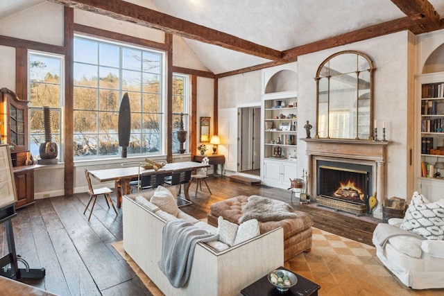 living room with hardwood / wood-style flooring, built in shelves, and lofted ceiling with beams