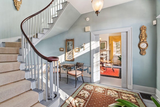 tiled entryway featuring high vaulted ceiling