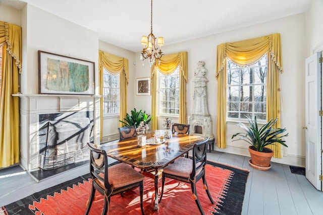 dining space with an inviting chandelier, hardwood / wood-style floors, and a fireplace