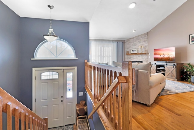 foyer featuring lofted ceiling, a fireplace, and light hardwood / wood-style floors