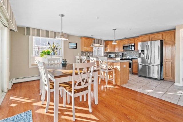 tiled dining room with a baseboard radiator