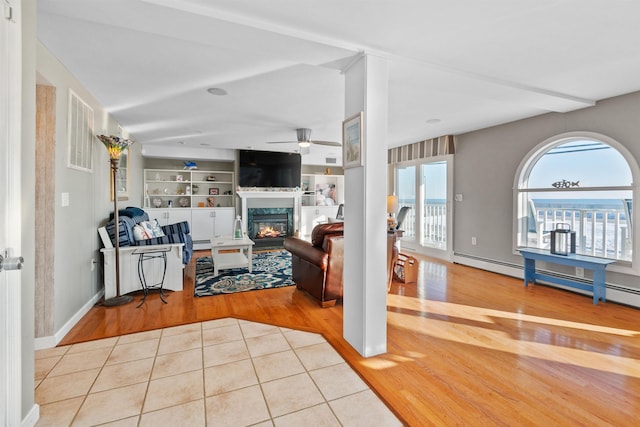 living room featuring ceiling fan, built in features, and light tile patterned floors