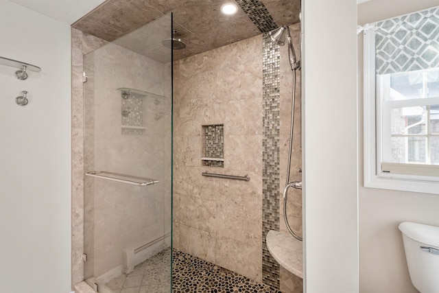 bathroom featuring toilet and tiled shower