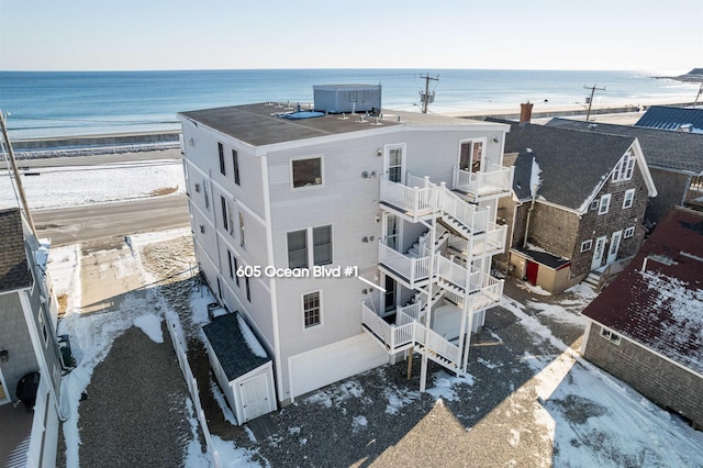 drone / aerial view featuring a water view and a view of the beach