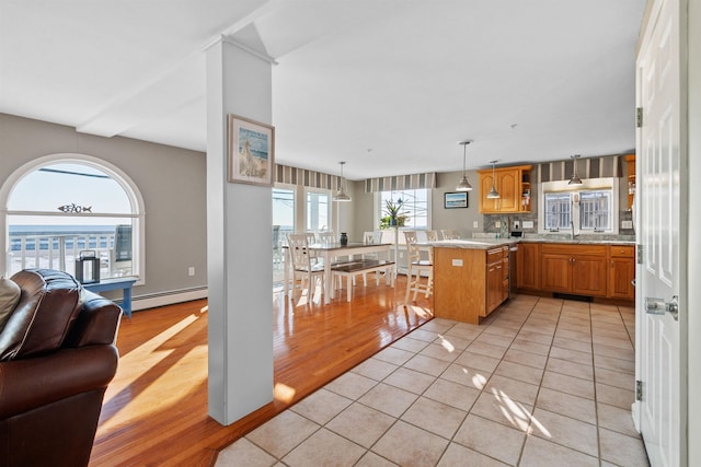 kitchen featuring pendant lighting, a baseboard radiator, decorative backsplash, light tile patterned floors, and kitchen peninsula