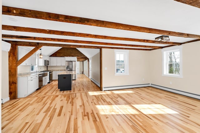 95 Plymouth St, Meredith, NH 03253 - kitchen with appliances with stainless steel finishes, light wood-style flooring, plenty of natural light, white cabinetry, and beam ceiling