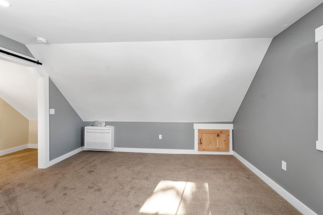 95 Plymouth St, Meredith, NH 03253 - additional living space featuring vaulted ceiling, carpet, baseboards, and a barn door
