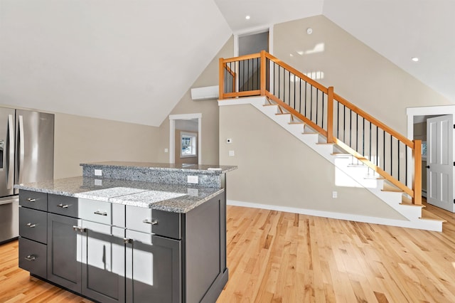 95 Plymouth St, Meredith, NH 03253 - kitchen featuring stainless steel fridge with ice dispenser, light wood-type flooring, lofted ceiling, light stone countertops, and a kitchen island
