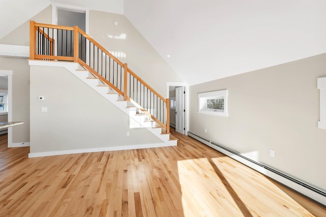 95 Plymouth St, Meredith, NH 03253 - stairway with a baseboard heating unit, wood finished floors, high vaulted ceiling, and plenty of natural light