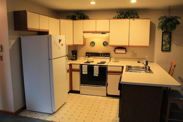 kitchen featuring sink, white appliances, and kitchen peninsula