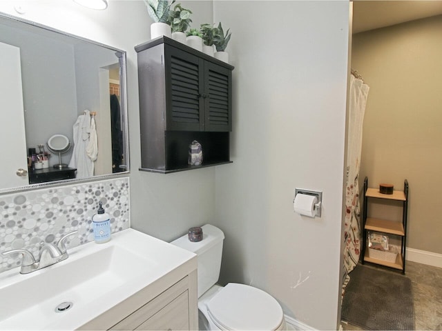 bathroom with vanity, toilet, and decorative backsplash