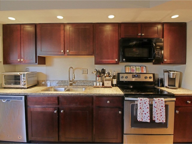 kitchen featuring stainless steel appliances, light stone countertops, and sink