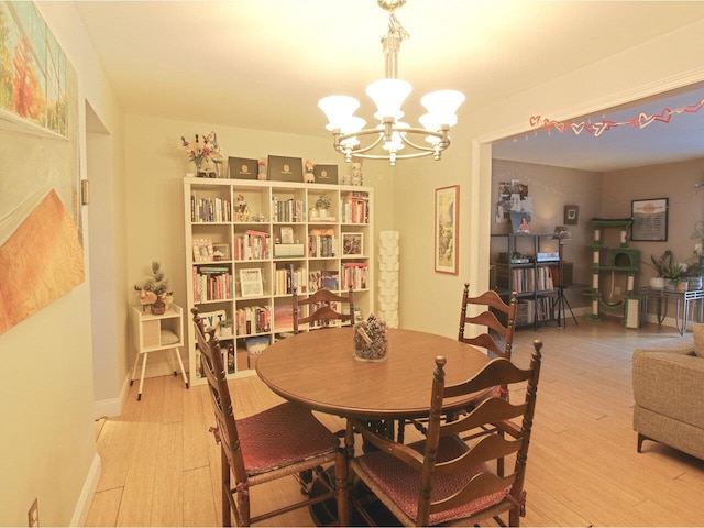 dining area featuring an inviting chandelier and light hardwood / wood-style flooring