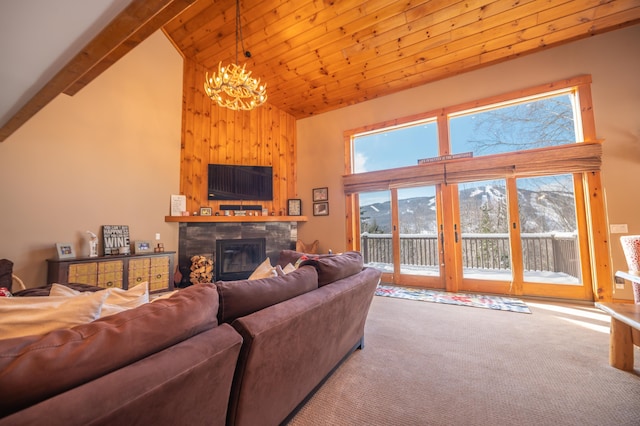 living room with a stone fireplace, a chandelier, high vaulted ceiling, beamed ceiling, and light colored carpet