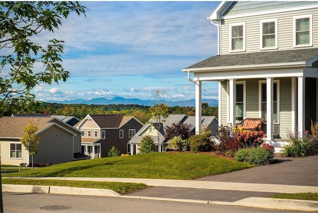 exterior space with a yard, a mountain view, and covered porch