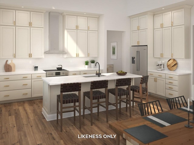 kitchen featuring sink, decorative backsplash, a kitchen island with sink, stainless steel appliances, and wall chimney range hood