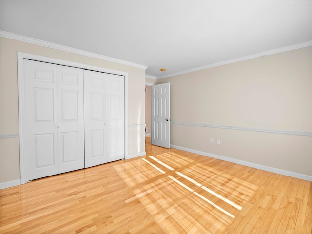 unfurnished bedroom with ornamental molding, a closet, and light wood-type flooring