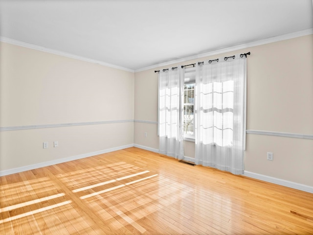 empty room with hardwood / wood-style flooring and ornamental molding