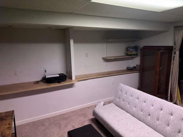 sitting room featuring carpet flooring and a drop ceiling