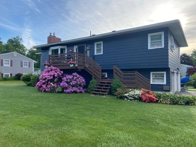 view of front facade with a wooden deck and a front yard