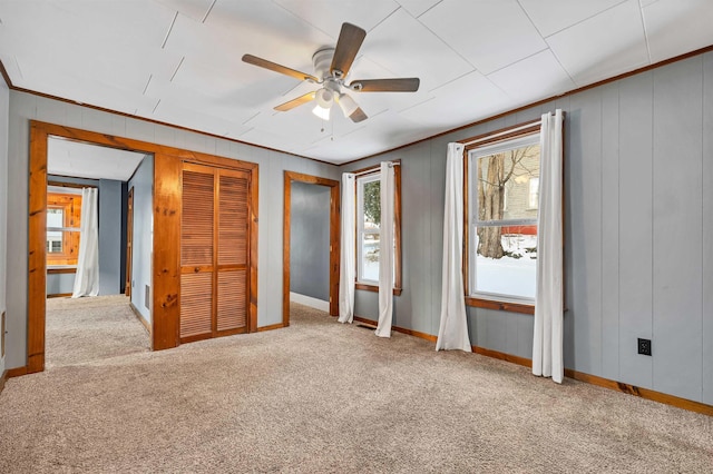 unfurnished bedroom with light carpet, crown molding, and ceiling fan