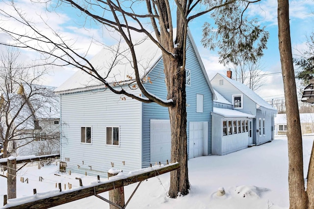 view of snowy exterior featuring a garage