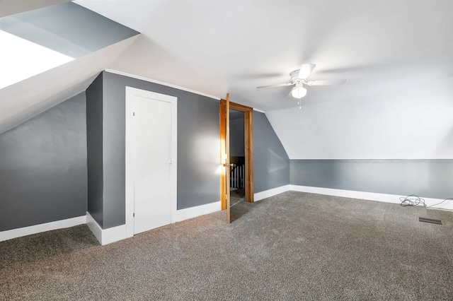 additional living space featuring lofted ceiling, ceiling fan, and dark colored carpet