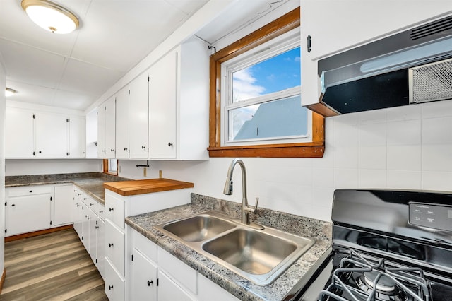 kitchen with black gas range oven, range hood, white cabinetry, sink, and dark wood-type flooring