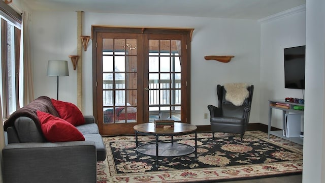 living room featuring french doors, ornamental molding, and a wealth of natural light