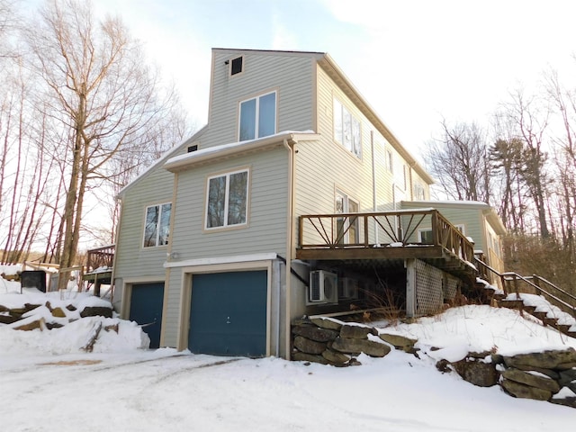 view of snowy exterior featuring a garage and a deck