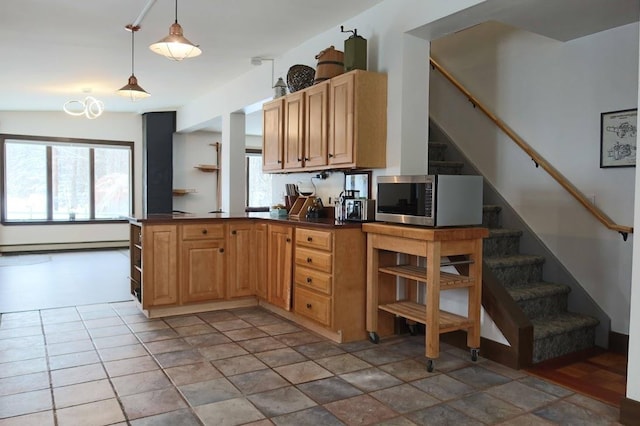 kitchen with a baseboard heating unit, decorative light fixtures, kitchen peninsula, and a wealth of natural light