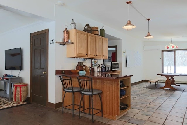 kitchen with a kitchen bar, a wall mounted air conditioner, hanging light fixtures, kitchen peninsula, and tile patterned flooring