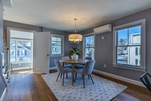 dining room featuring a healthy amount of sunlight, dark hardwood / wood-style floors, and a wall mounted AC