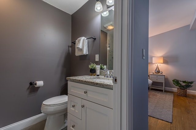 bathroom featuring vanity, hardwood / wood-style flooring, and toilet