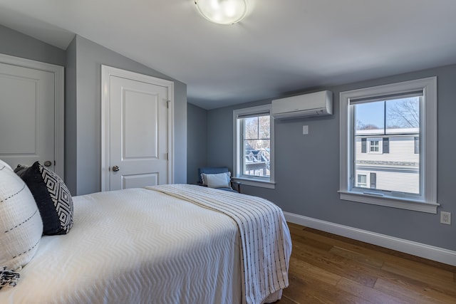 bedroom featuring hardwood / wood-style flooring, vaulted ceiling, and a wall mounted AC