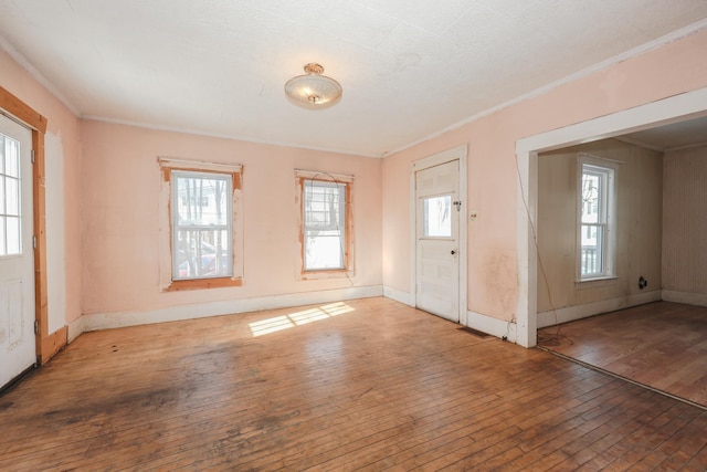 entrance foyer with ornamental molding and hardwood / wood-style floors