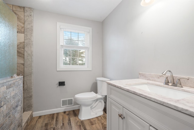 bathroom with vanity, hardwood / wood-style flooring, toilet, and a shower