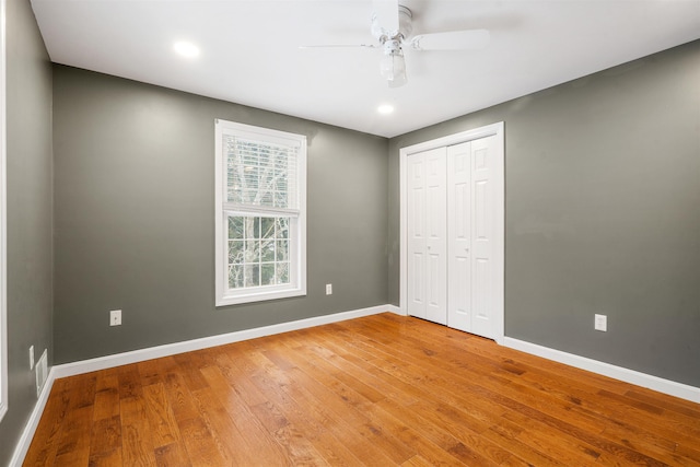 unfurnished bedroom with hardwood / wood-style floors, a closet, and ceiling fan