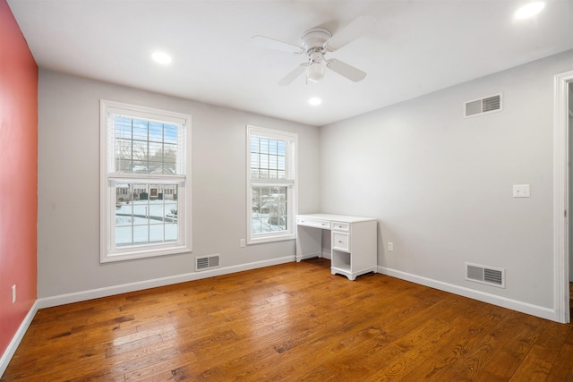 unfurnished office with hardwood / wood-style flooring and ceiling fan