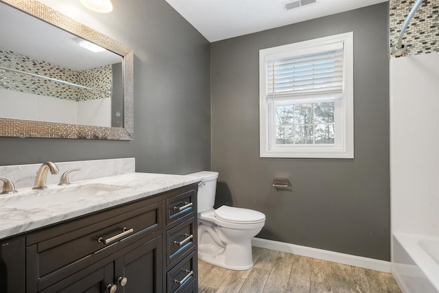 full bathroom with vanity, hardwood / wood-style flooring, shower / tub combination, and toilet