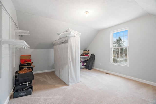 bonus room with vaulted ceiling and light colored carpet